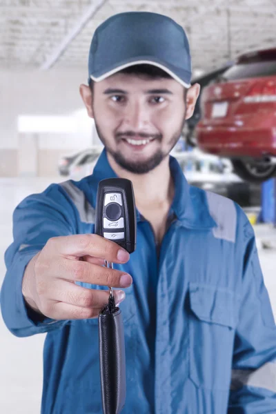 Mecânico masculino dá uma chave de carro na oficina — Fotografia de Stock
