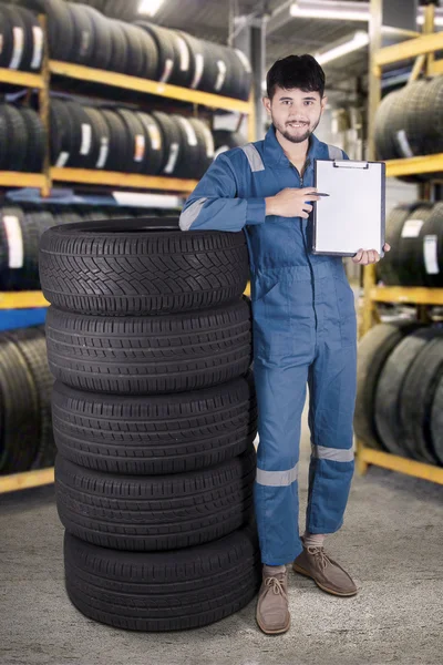 Mecânico mostra área de transferência em branco na oficina — Fotografia de Stock