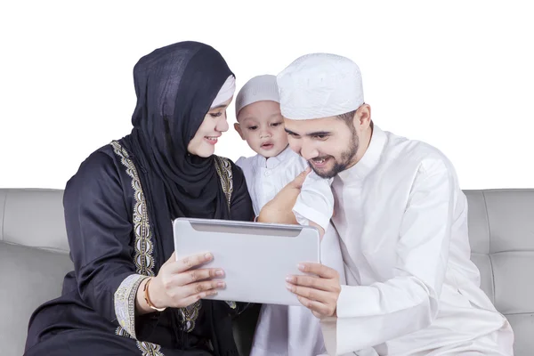 Мусульманская семья использует планшет на диване — стоковое фото