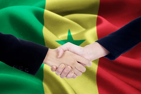 Partnership handshake with flag of Senegal — Stock Photo, Image