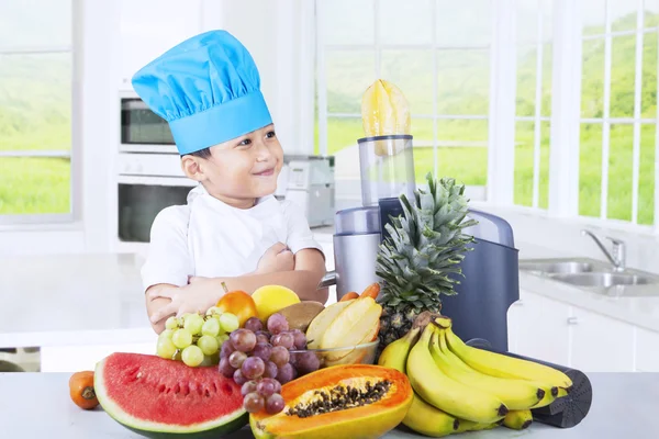 Niño haciendo jugo de frutas en la cocina Fotos de stock libres de derechos