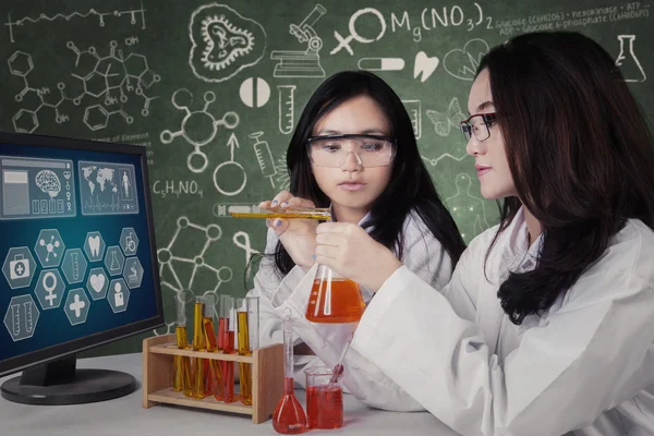 Estudiantes femeninas mezclan el líquido químico — Foto de Stock