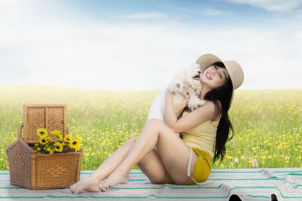 Hübsches Mädchen umarmt einen Hund auf dem Feld — Stockfoto