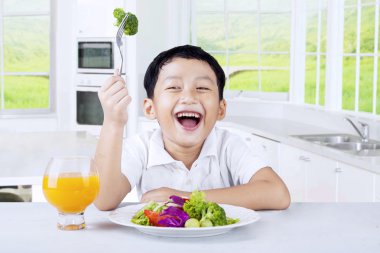 Mutlu küçük çocuk zevk sebze salatası
