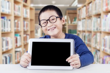 Küçük çocuk tablet ile boş perde tutar