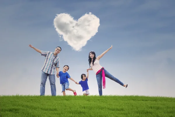 Familia feliz en el campo con símbolo del corazón — Foto de Stock