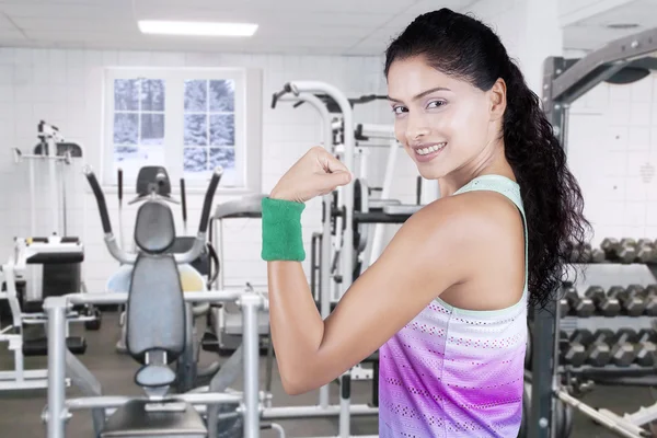 Femme montrant biceps à la salle de gym en saison d'hiver — Photo