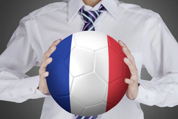 Businessman holds ball with France flag — Stock Photo, Image