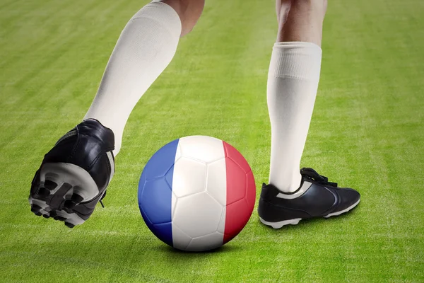 Pied du footballeur jouer au ballon avec un drapeau de la France — Photo