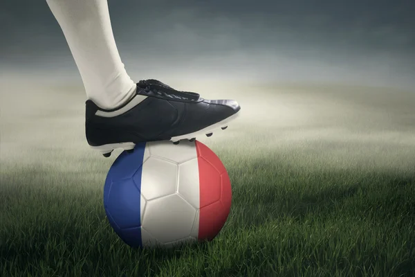 Piede di calciatore con palla e bandiera della Francia — Foto Stock