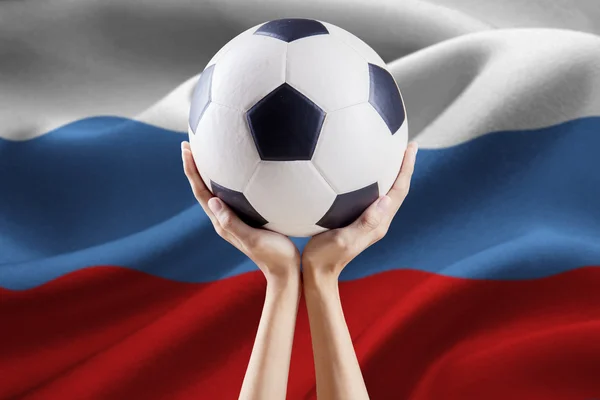 Manos sosteniendo la pelota con la bandera de Rusia —  Fotos de Stock