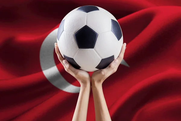 Manos sosteniendo la pelota con la bandera de Turquía —  Fotos de Stock