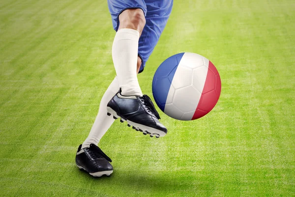 Soccer player kicking a ball at field — Stock Photo, Image