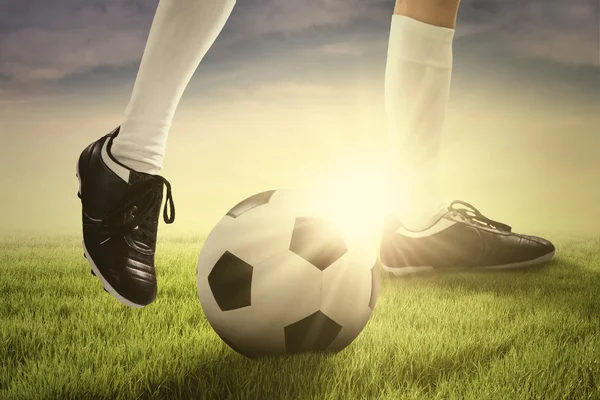 Jogador de futebol jogando uma bola — Fotografia de Stock