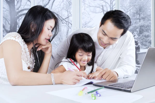 Familj gör skolarbete hemma — Stockfoto