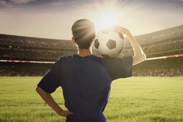 Fotbollsspelare hålla bollen på axeln — Stockfoto