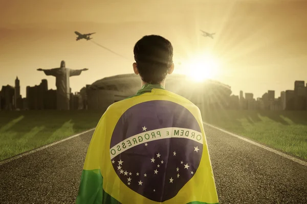 Hombre con bandera brasileña en el camino —  Fotos de Stock