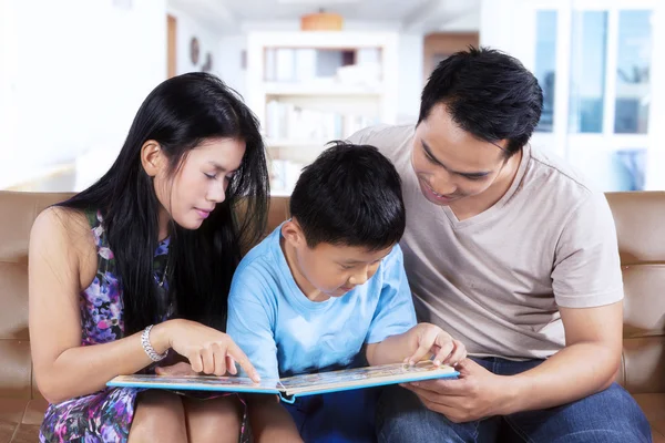 Padres y su hijo leen libro de cuentos —  Fotos de Stock