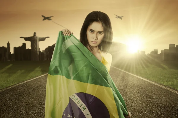 Bonita modelo con bandera brasileña en la carretera — Foto de Stock