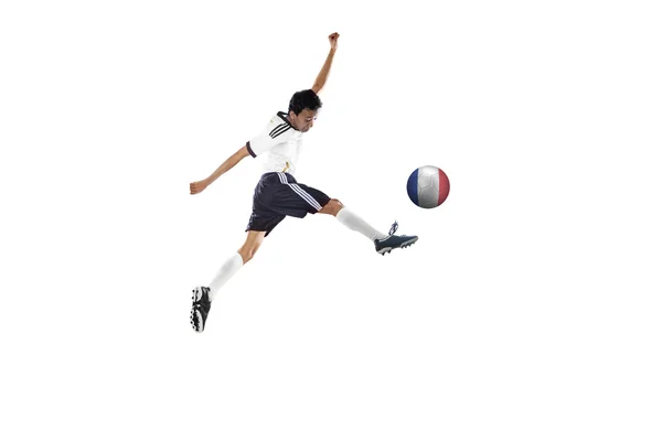 Soccer player jumping while kicking the ball — Stock Photo, Image