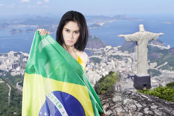 Mulher segura bandeira brasileira na cidade — Fotografia de Stock