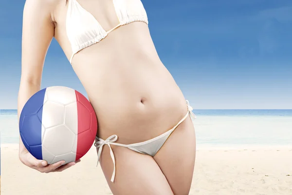 Donna con costumi da bagno e pallone da calcio — Foto Stock