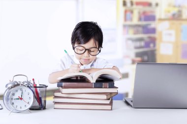 Sevimli öğrenci sınıf kitapta yazıyor