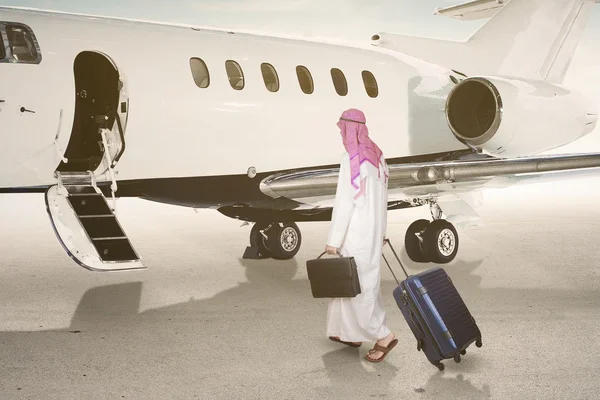 Uomo d'affari arabo che cammina verso il jet — Foto Stock