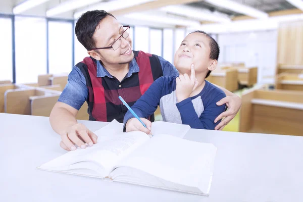 Freundliche Lehrerin unterrichtet einen kleinen Jungen — Stockfoto