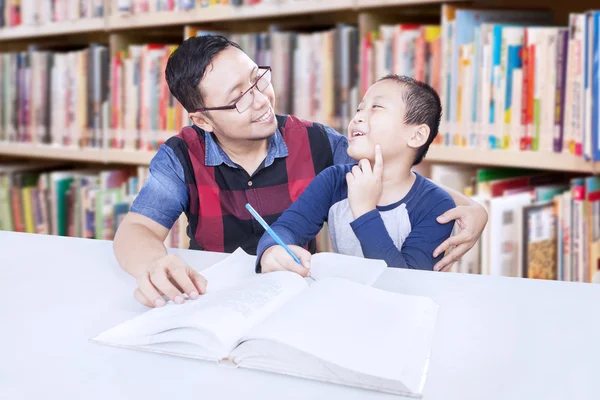 Man onderwijzen van een jongen in de bibliotheek — Stockfoto