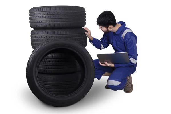 Verificação mecânica pneus enquanto segurando laptop — Fotografia de Stock