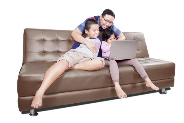 Zwei Kinder und Vater mit Laptop auf dem Sofa — Stockfoto