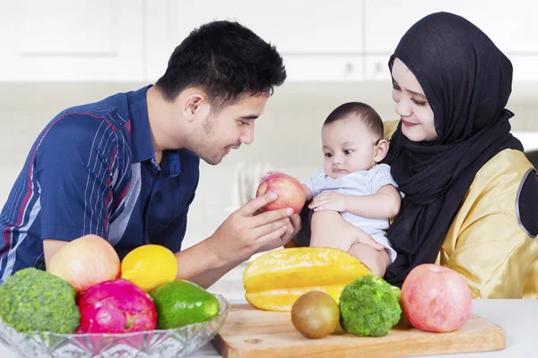 Twee ouders met kleine zoon en vruchten — Stockfoto