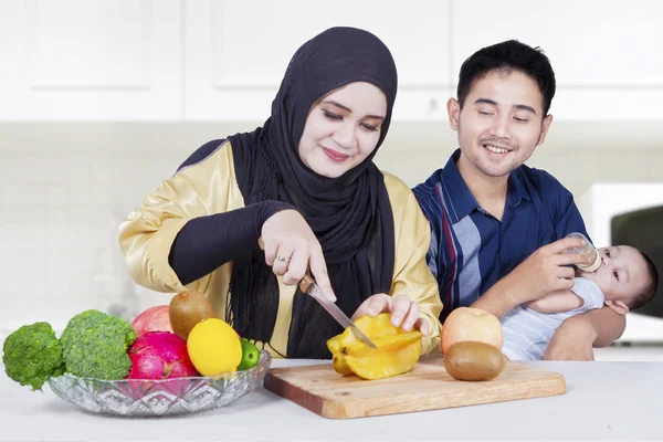 Padres jóvenes e hijo cocinando con frutas —  Fotos de Stock