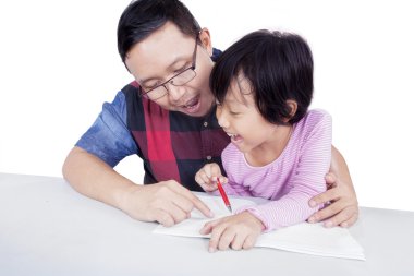 Baba kızını çalışmaya yardımcı olur.