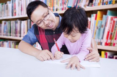 Erkek öğretmen öğrenci yazmak için yardımcı olur.