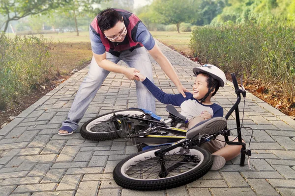Criança fica acidente e ajudado pelo pai — Fotografia de Stock