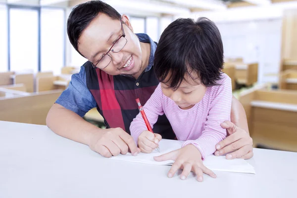 Elementary student studying with her teacher — Stock Photo, Image