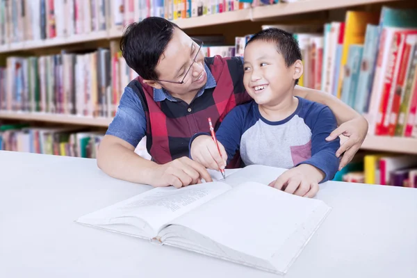 Вчитель допомагає маленькому хлопчику вчитися — стокове фото