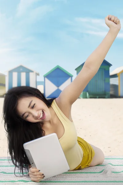 Mujer feliz utiliza tableta en la orilla — Foto de Stock