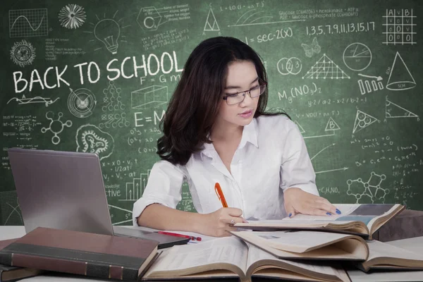 Adolescente faisant tâche scolaire en classe — Photo