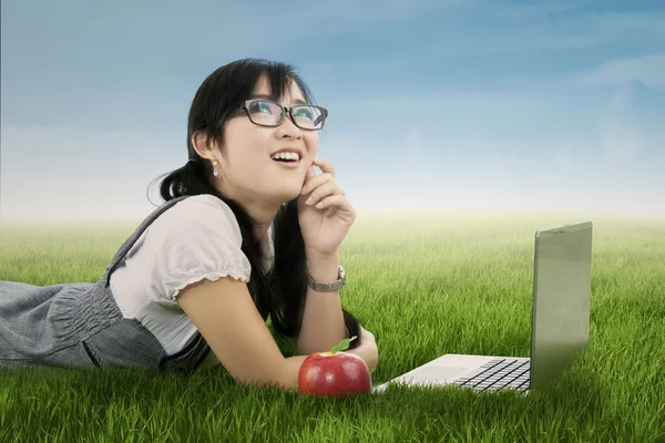 Pretty female student daydreaming on meadow — Stock Photo, Image