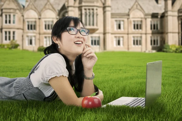 Mujer pensativa estudiante en la hierba —  Fotos de Stock