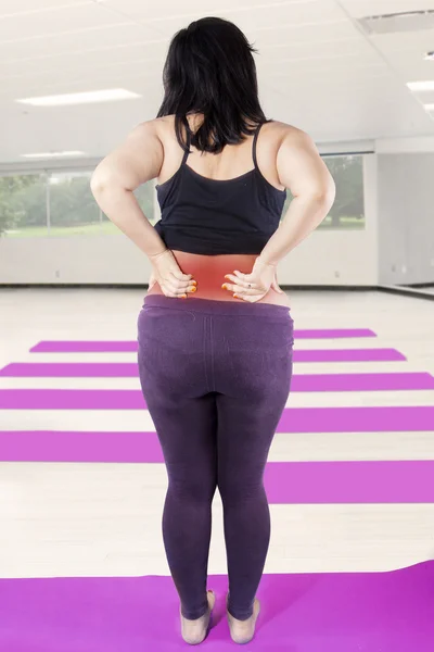 Mujer embarazada con dolor de espalda en el gimnasio — Foto de Stock