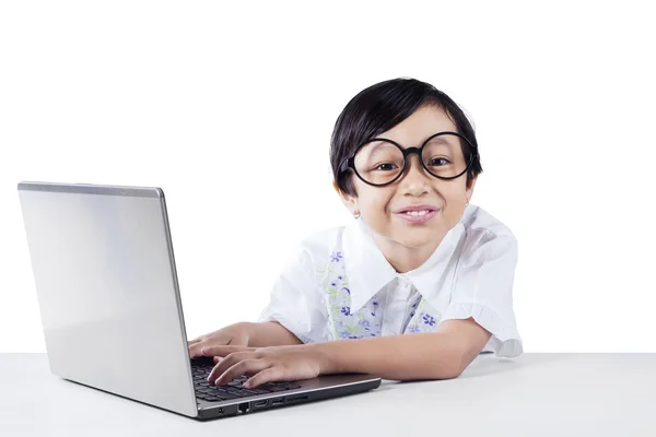 Attractive little girl uses laptop and smiling — Stock Photo, Image