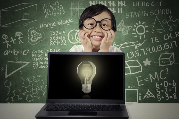 Niño con bombilla en monitor portátil — Foto de Stock