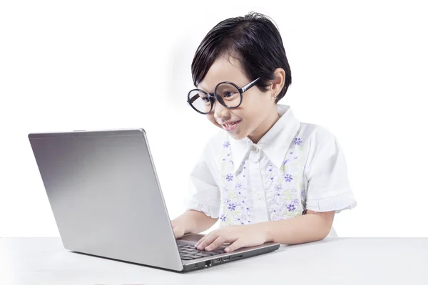 Cute girl uses notebook computer on desk — Stock Photo, Image