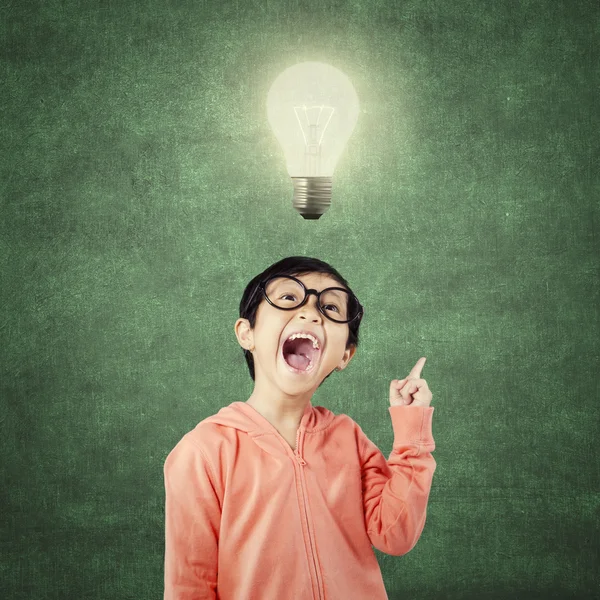 Intelligent kind krijgt idee onder heldere gloeilamp — Stockfoto