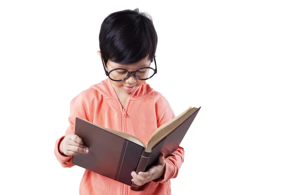 Pequena estudante lê livro em estúdio — Fotografia de Stock