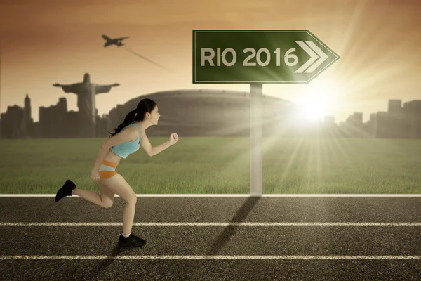 Женщина бегает с указателем Рио-2016 — стоковое фото
